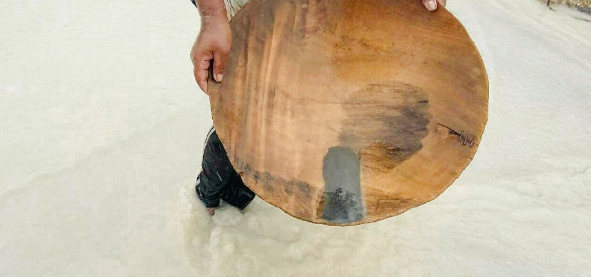 ชายคนหนึ่งถือชามไม้ในน้ำ สื่อถึงความสงบและการเชื่อมต่อกับธรรมชาติอย่างลึกซึ้ง