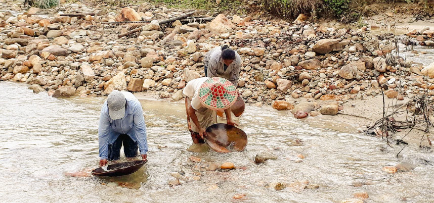 สองคนทำงานในแม่น้ำโดยใช้ถังเพื่อเก็บน้ำหรือสิ่งของจากแม่น้ำ