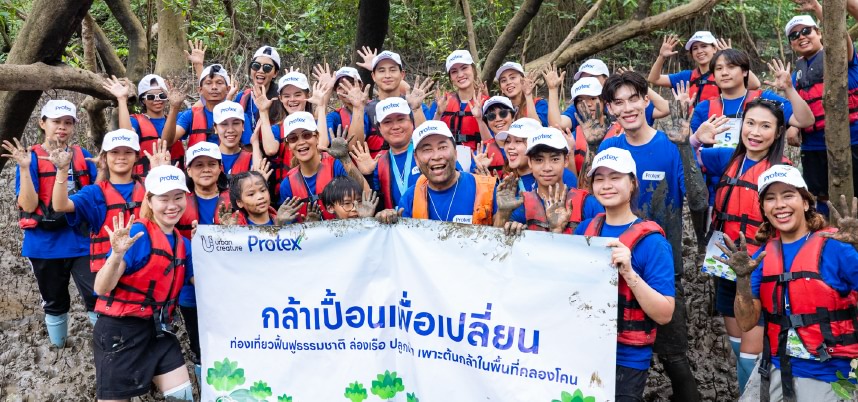 กลุ่มคนสวมเสื้อกั๊กสีน้ำเงินถือป้ายข้อความร่วมกันในกิจกรรมที่มีความหมายสำคัญ