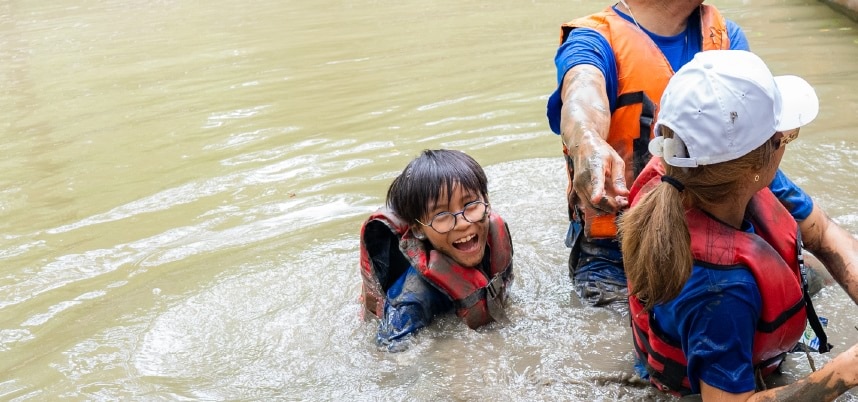 ผู้คนหลายคนสวมเสื้อชูชีพและเสื้อกั๊กชูชีพกำลังอยู่ในน้ำ