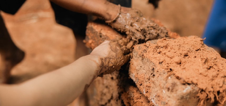 สองผู้คนกำลังทำงานบนผนังในพื้นที่ดิน มีการใช้เครื่องมือและอุปกรณ์ต่างๆ เพื่อดำเนินการ