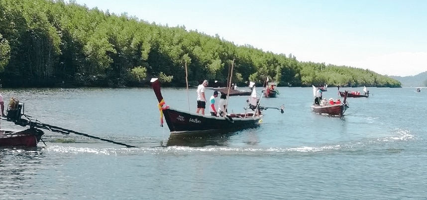 เรือหลายลำลอยอยู่บนผิวน้ำ มีผู้คนอยู่บนเรือแต่ละลำอย่างมีชีวิตชีวา