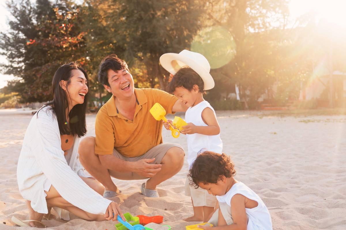 ครอบครัวกำลังเล่นทรายและใช้เวลาร่วมกันอย่างมีความสุขบนชายหาด