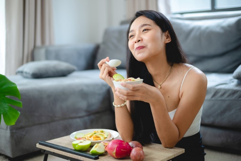 A woman holding a cup of healthy food