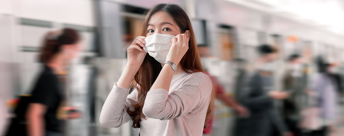 ผู้หญิงใส่หน้ากากรอขึ้นรถไฟฟ้า